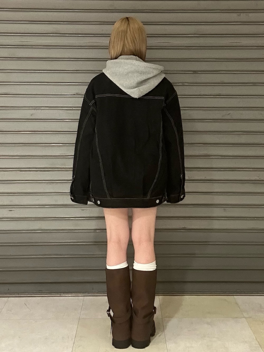 ブルー系のブルゾン、グレー系のパーカー、ブルー系のスカートを着用したレディースの冬コーディネートの4枚目の写真