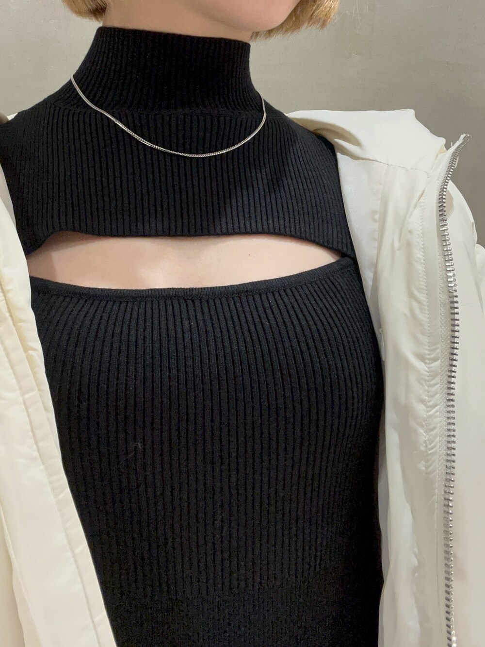 ブラック系のワンピース、ブルー系のハンドバッグ、ホワイト系のダウンジャケット/コートを着用したレディースの冬コーディネートの7枚目の写真