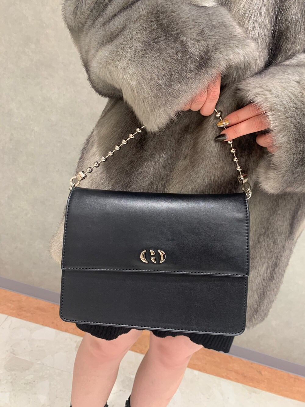 グレー系のその他アウター、ブラック系のブーツ、ブラック系のハンドバッグを着用したレディースの冬コーディネートの6枚目の写真