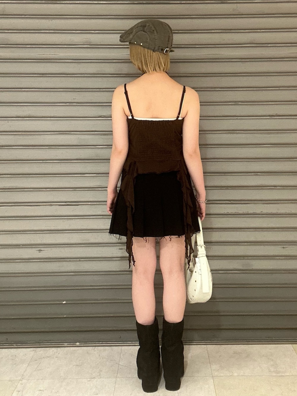 ブラウン系のTシャツ/カットソー、ブラック系のスカート、ブラック系のサンダルを着用したレディースの春コーディネートの3枚目の写真