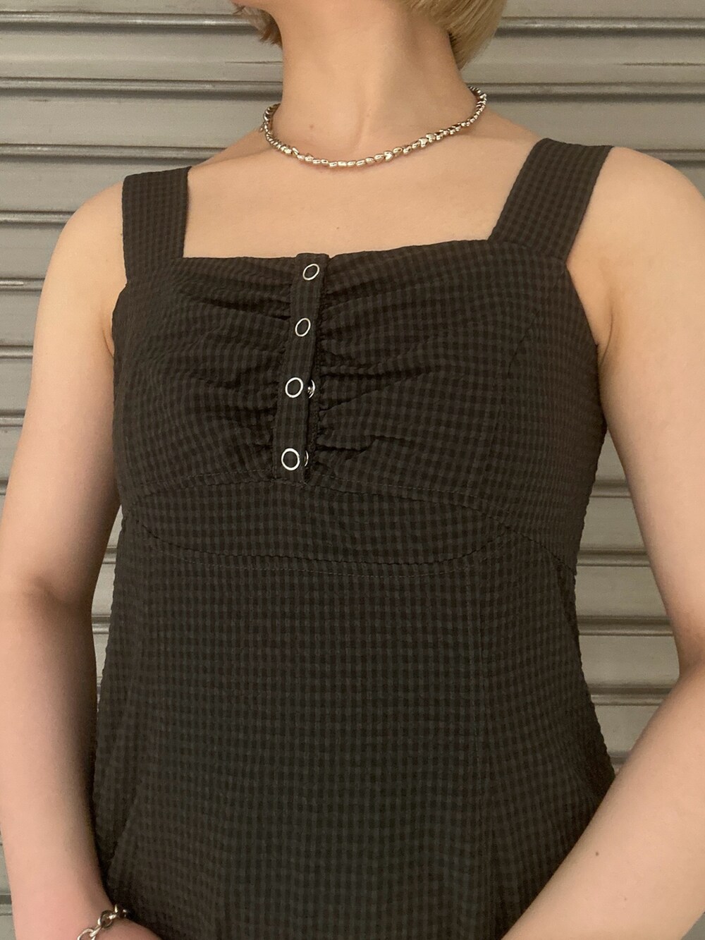 グレー系のワンピース、ホワイト系のハンドバッグ、ホワイト系のパンプスを着用したレディースの春コーディネートの4枚目の写真