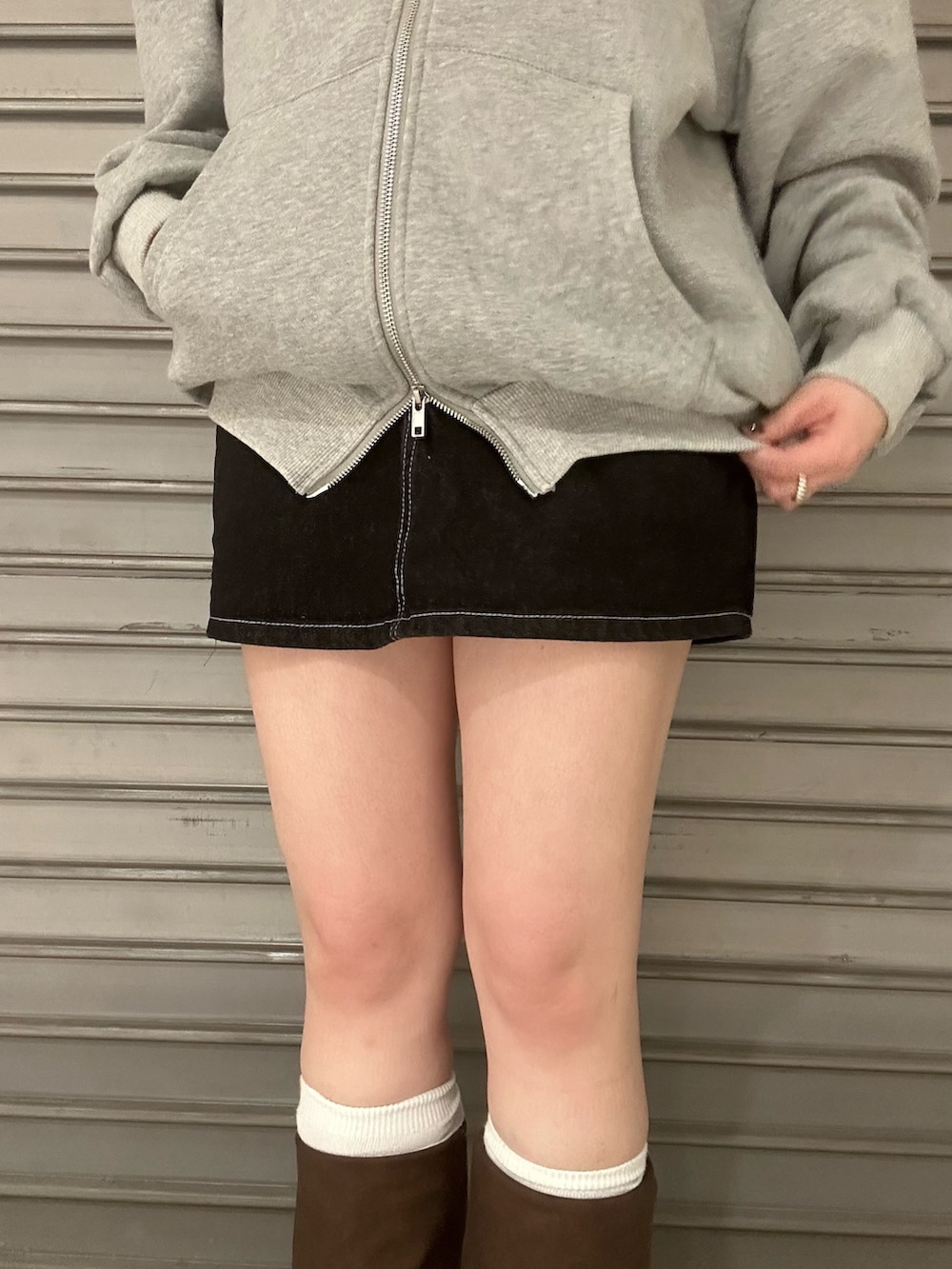 ブルー系のブルゾン、グレー系のパーカー、ブルー系のスカートを着用したレディースの冬コーディネートの6枚目の写真