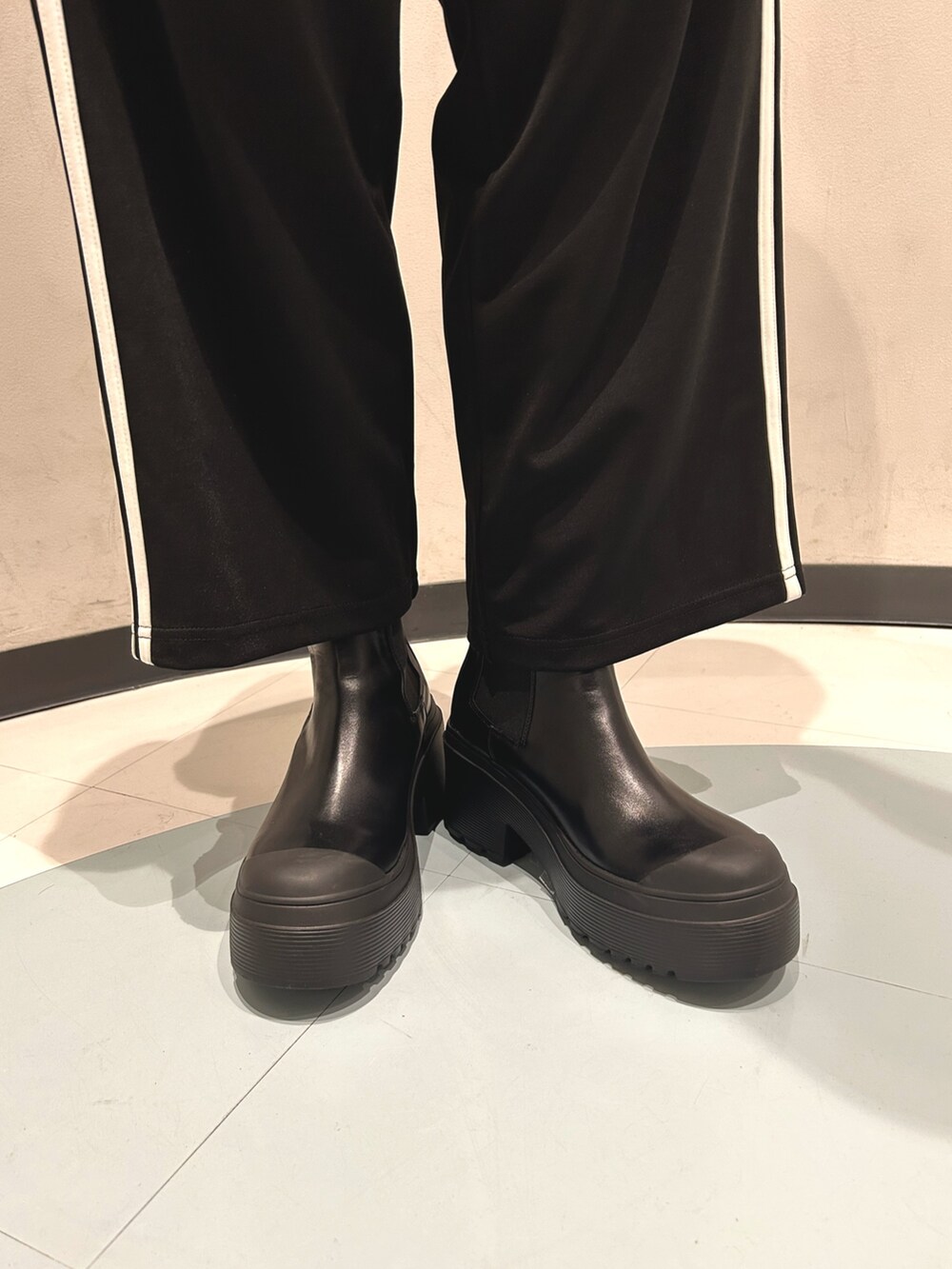 ホワイト系のTシャツ/カットソー、ブラック系のその他パンツ、ブラック系のブーツを着用したレディースの夏コーディネートの5枚目の写真