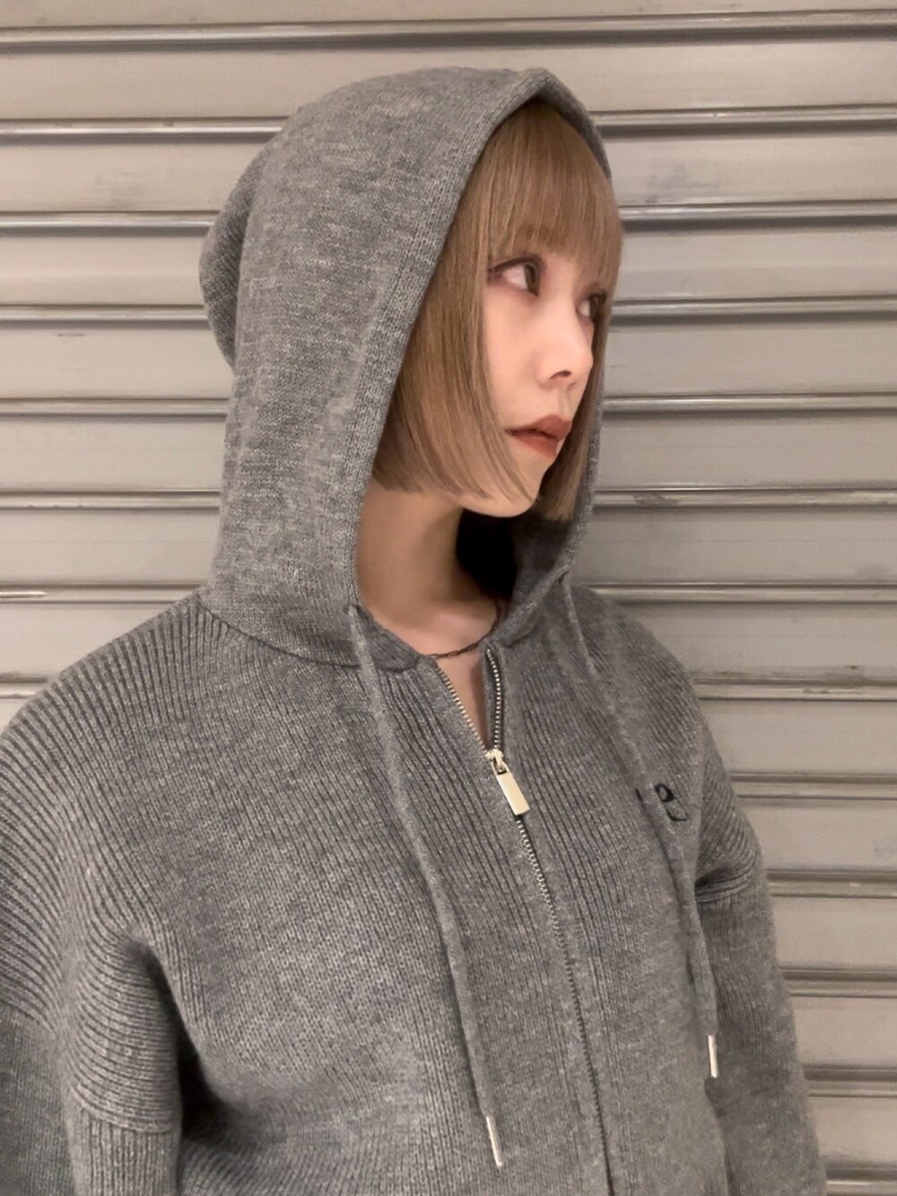 グレー系のニット/セーター、グレー系のスカート、その他のブーツを着用したレディースの秋コーディネートの6枚目の写真