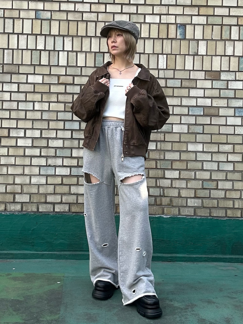 ブラウン系のブルゾン、ホワイト系のTシャツ/カットソー、グレー系のスウェットパンツを着用したレディースの秋コーディネートの2枚目の写真