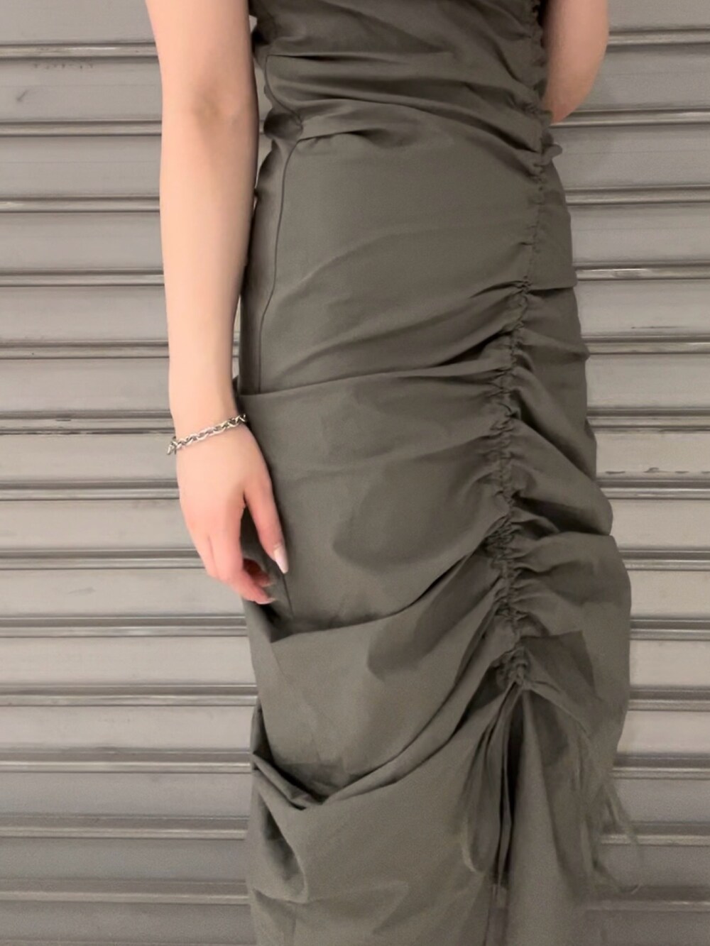 グリーン系のワンピース、ブラック系のサンダル、シルバー系のネックレスを着用したレディースの春コーディネートの4枚目の写真