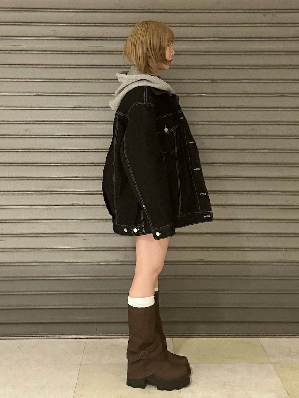 ブルー系のブルゾン、グレー系のパーカー、ブルー系のスカートを着用したレディースの冬コーディネートの3枚目の写真