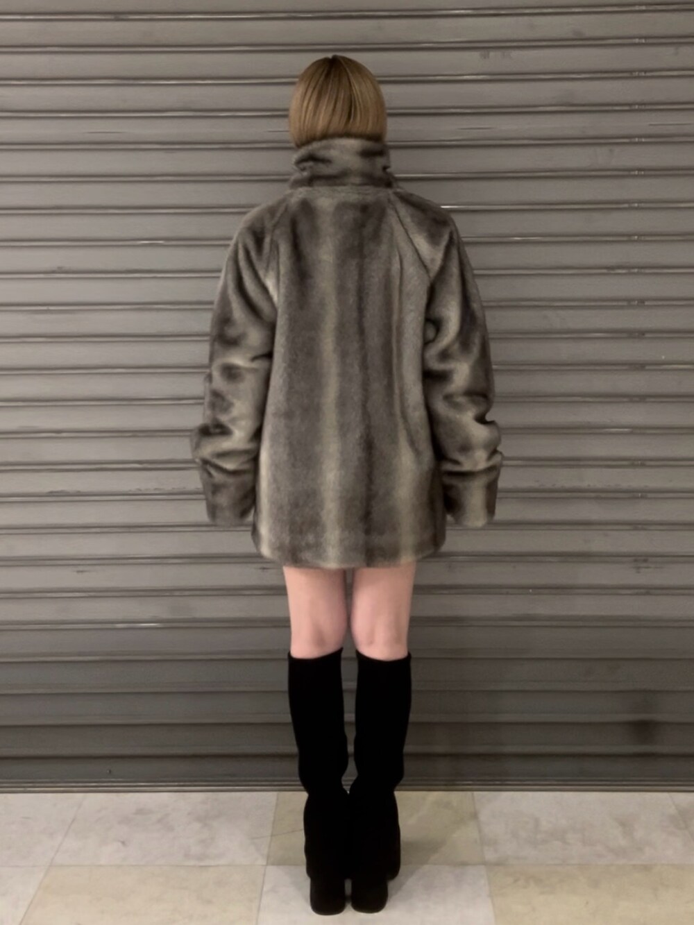 ブラック系のニット/セーター、グレー系のその他アウター、ブラック系のスカートを着用したレディースの冬コーディネートの6枚目の写真