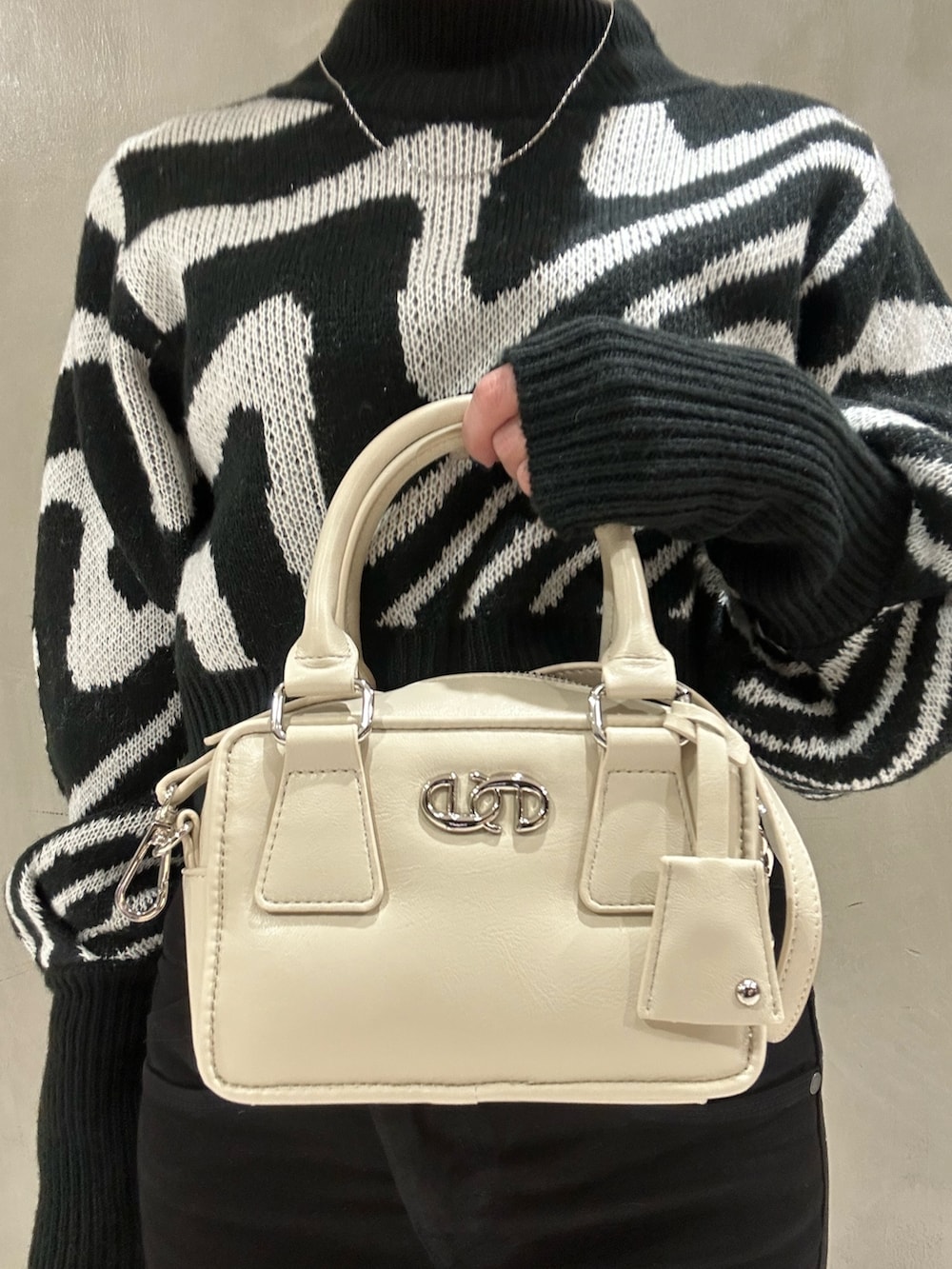 ホワイト系のダウンジャケット/コート、ブラック系のニット/セーター、ブラック系のデニムパンツを着用したレディースの冬コーディネートの9枚目の写真