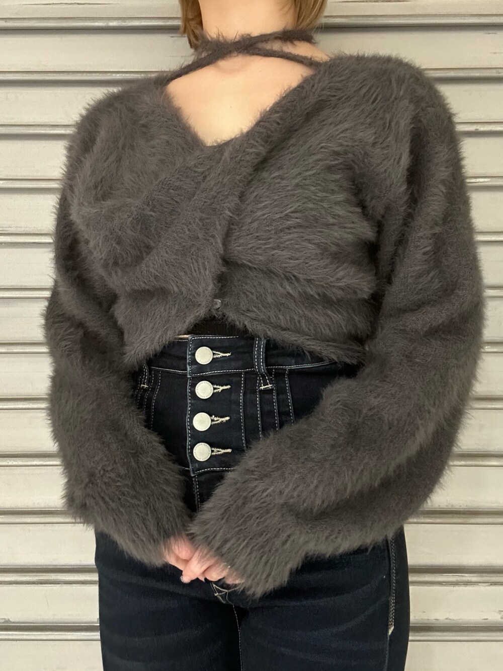 グレー系のニット/セーター、グレー系のTシャツ/カットソー、ブルー系のデニムパンツを着用したレディースの秋コーディネートの4枚目の写真