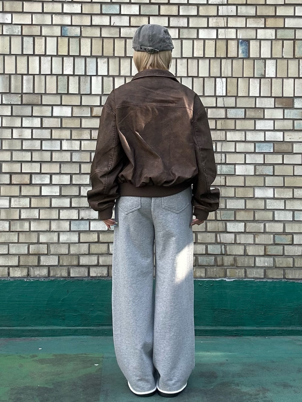 ブラウン系のブルゾン、ホワイト系のTシャツ/カットソー、グレー系のスウェットパンツを着用したレディースの秋コーディネートの4枚目の写真