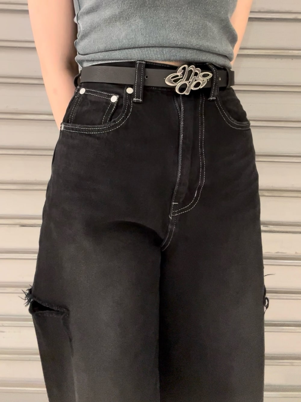 ブルー系のタンクトップ、ブラック系のデニムパンツ、ブラック系のハンドバッグを着用したレディースの夏コーディネートの6枚目の写真