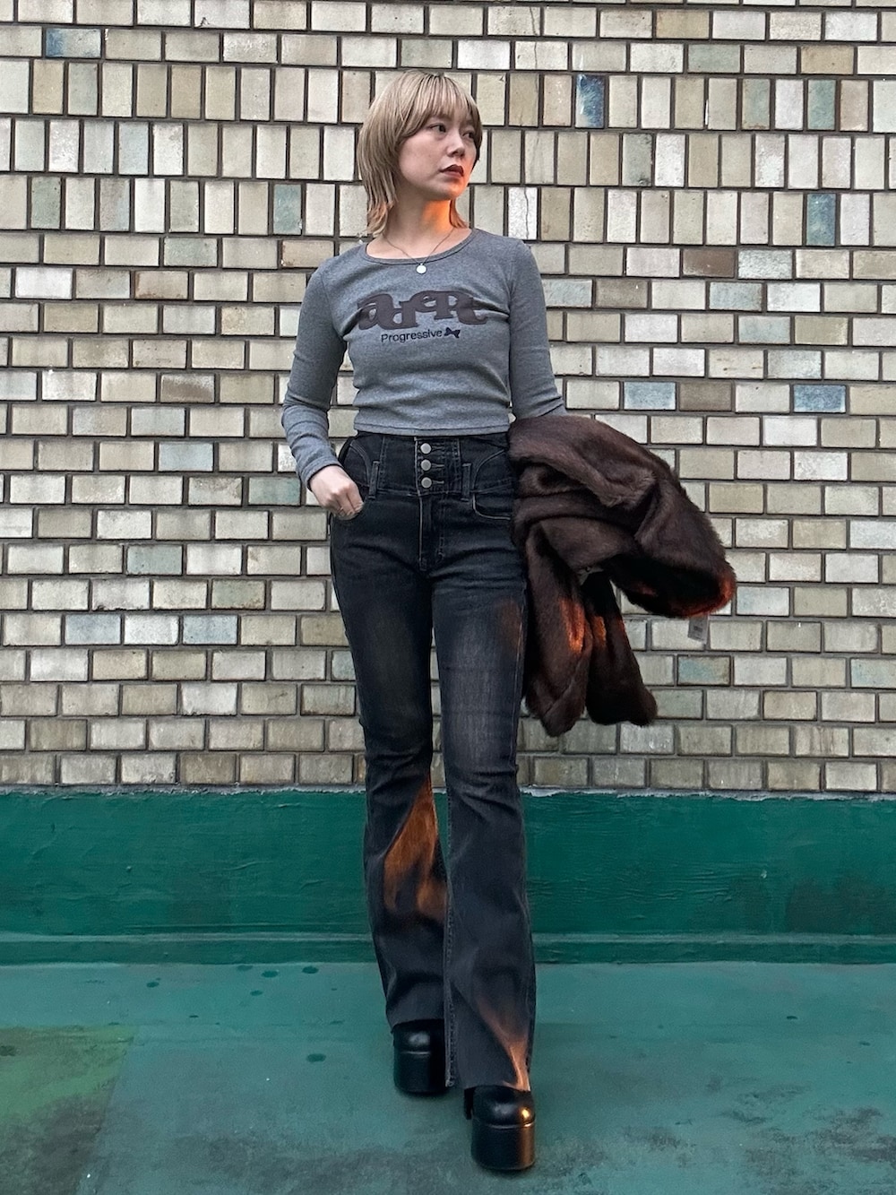 ブラック系のブーツ、ブラウン系のその他アウター、グレー系のTシャツ/カットソーを着用したレディースの秋コーディネートの3枚目の写真