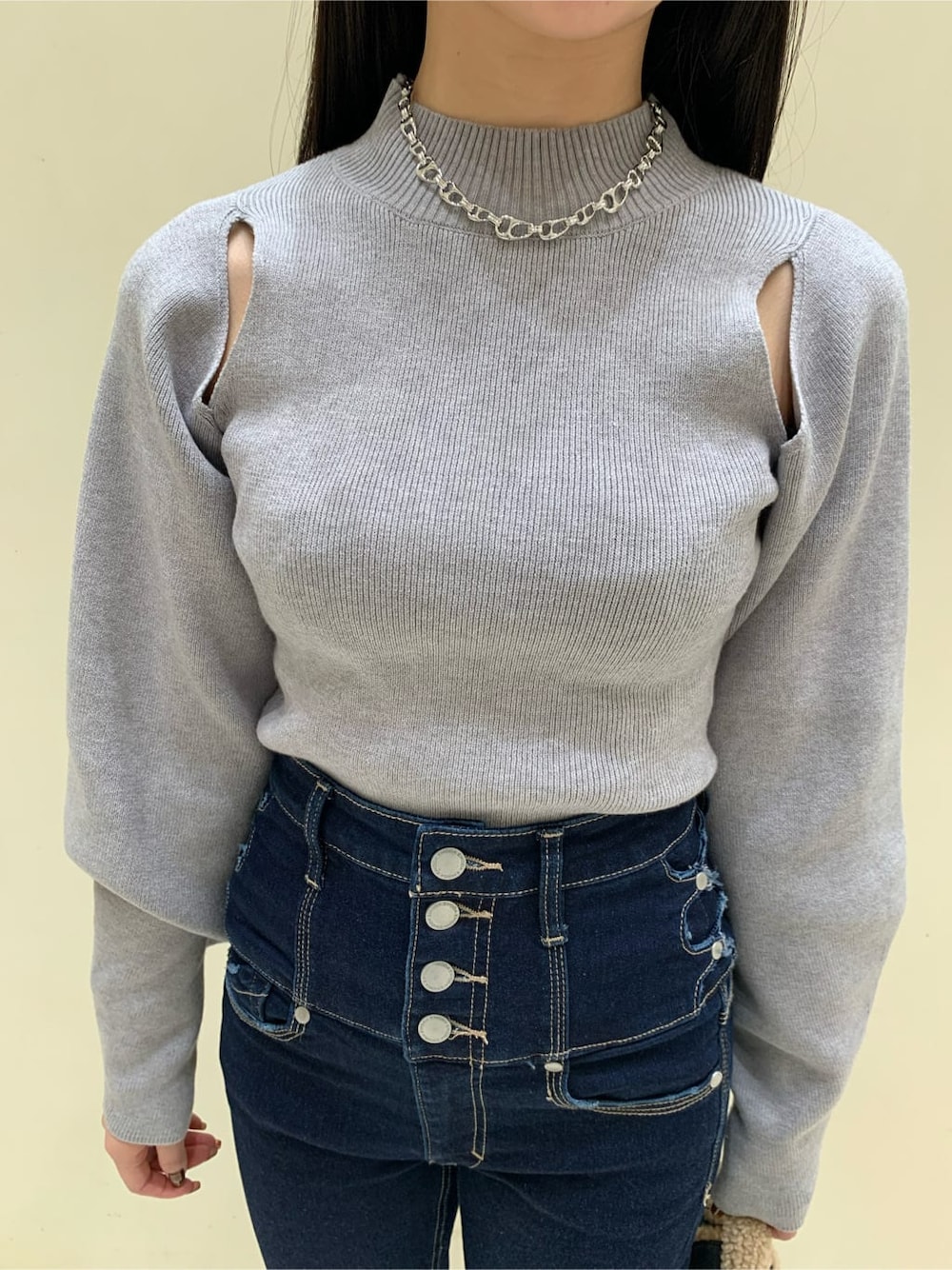 ブラック系のハンドバッグ、ブルー系のデニムパンツ、グレー系のニット/セーターを着用したレディースの秋コーディネートの3枚目の写真