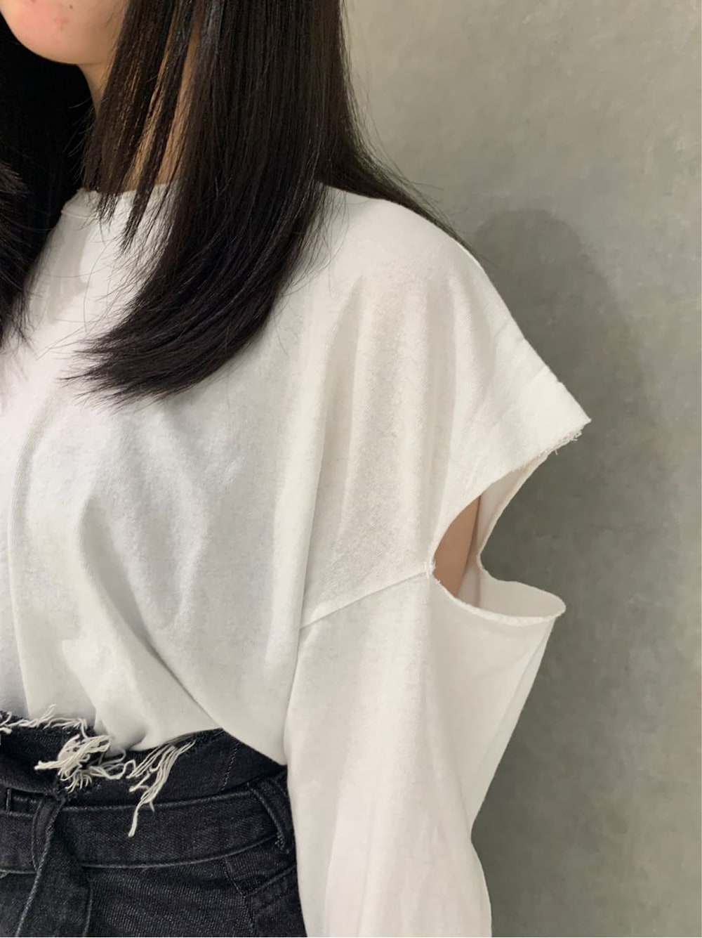 ブラック系のブーツ、ブラック系のデニムパンツ、ホワイト系のTシャツ/カットソーを着用したレディースの秋コーディネートの4枚目の写真