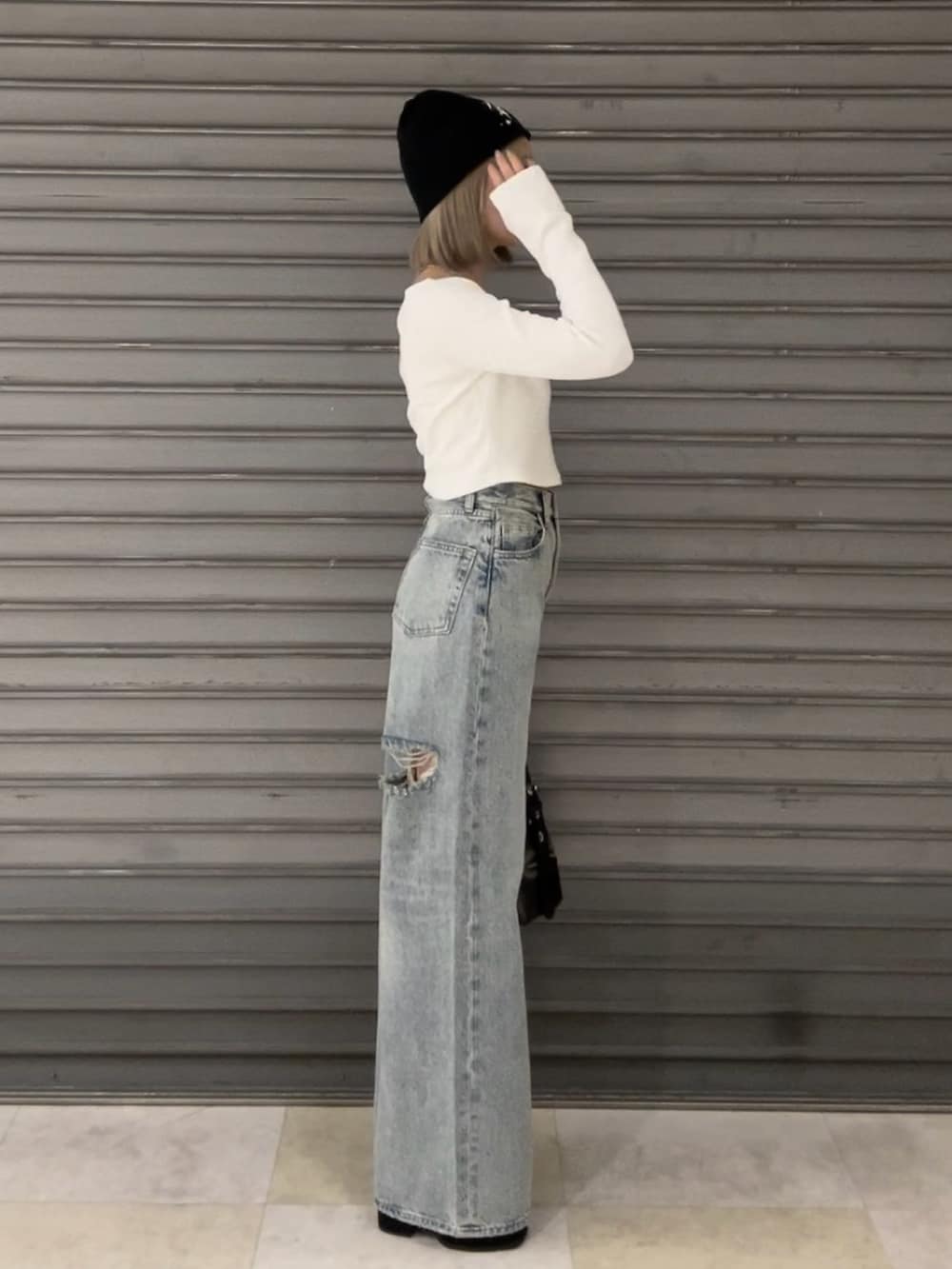 ホワイト系のTシャツ/カットソー、ブルー系のデニムパンツ、ブラック系のハンドバッグを着用したレディースの夏コーディネートの2枚目の写真