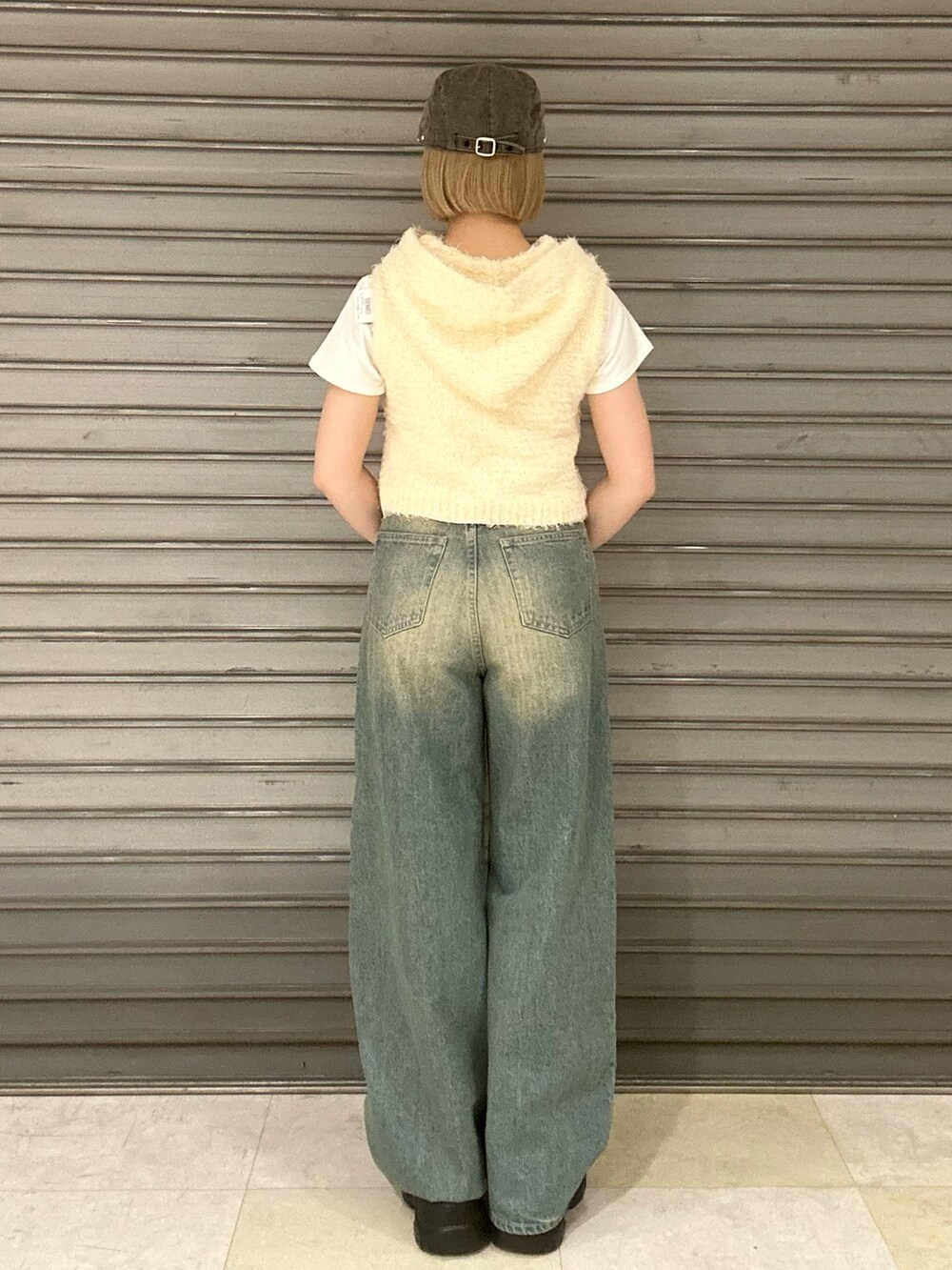 ホワイト系のニット/セーター、ホワイト系のTシャツ/カットソー、ブルー系のデニムパンツを着用したレディースの春コーディネートの3枚目の写真