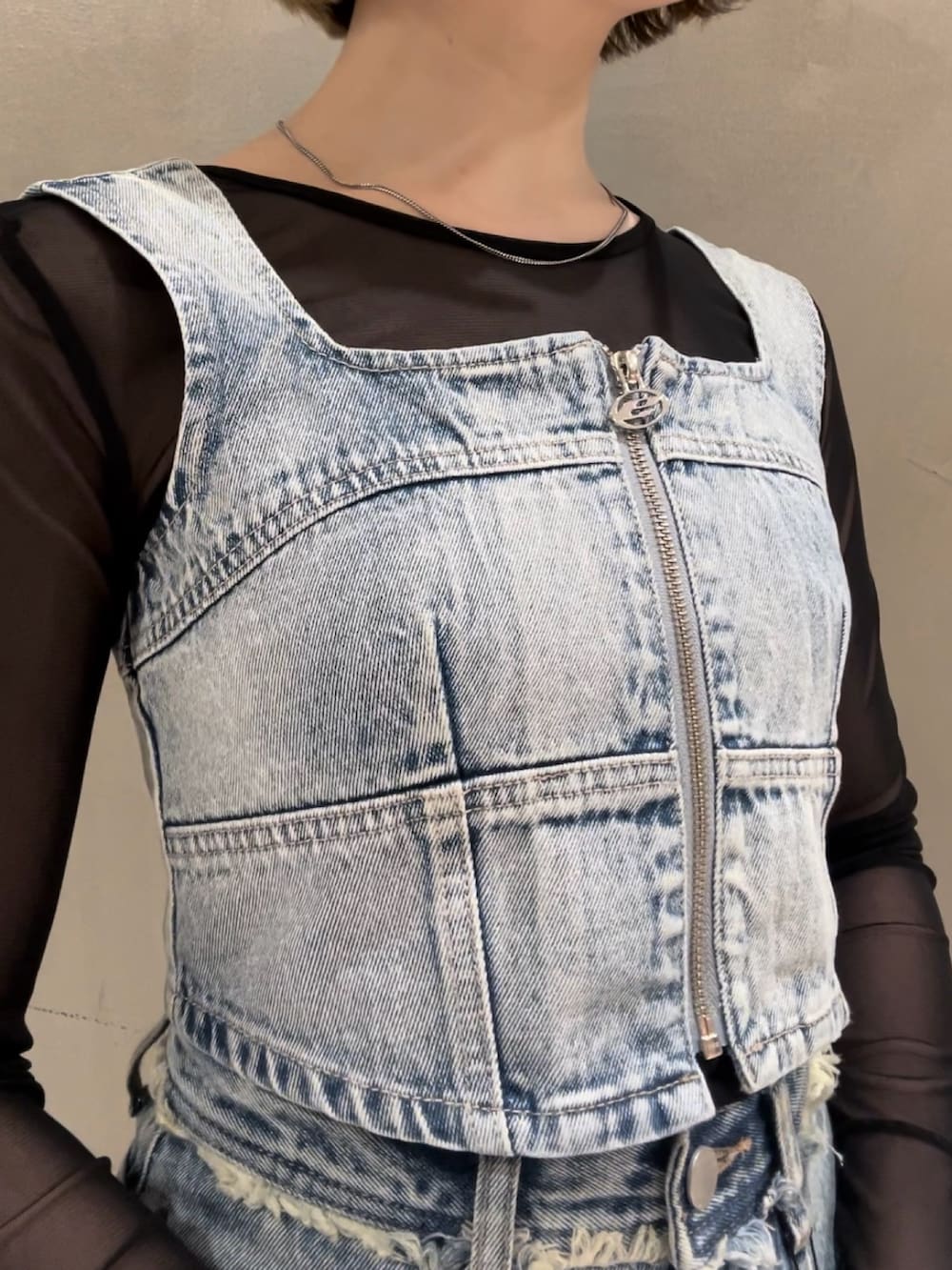 ブルー系のキャミソール、ブラック系のTシャツ/カットソー、ブルー系のデニムパンツを着用したレディースの春コーディネートの4枚目の写真