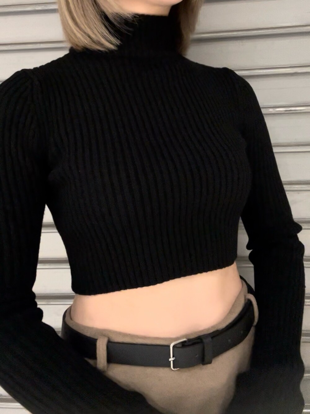 ホワイト系のダウンベスト、ブラック系のニット/セーター、ベージュ系のスカートを着用したレディースの秋コーディネートの8枚目の写真