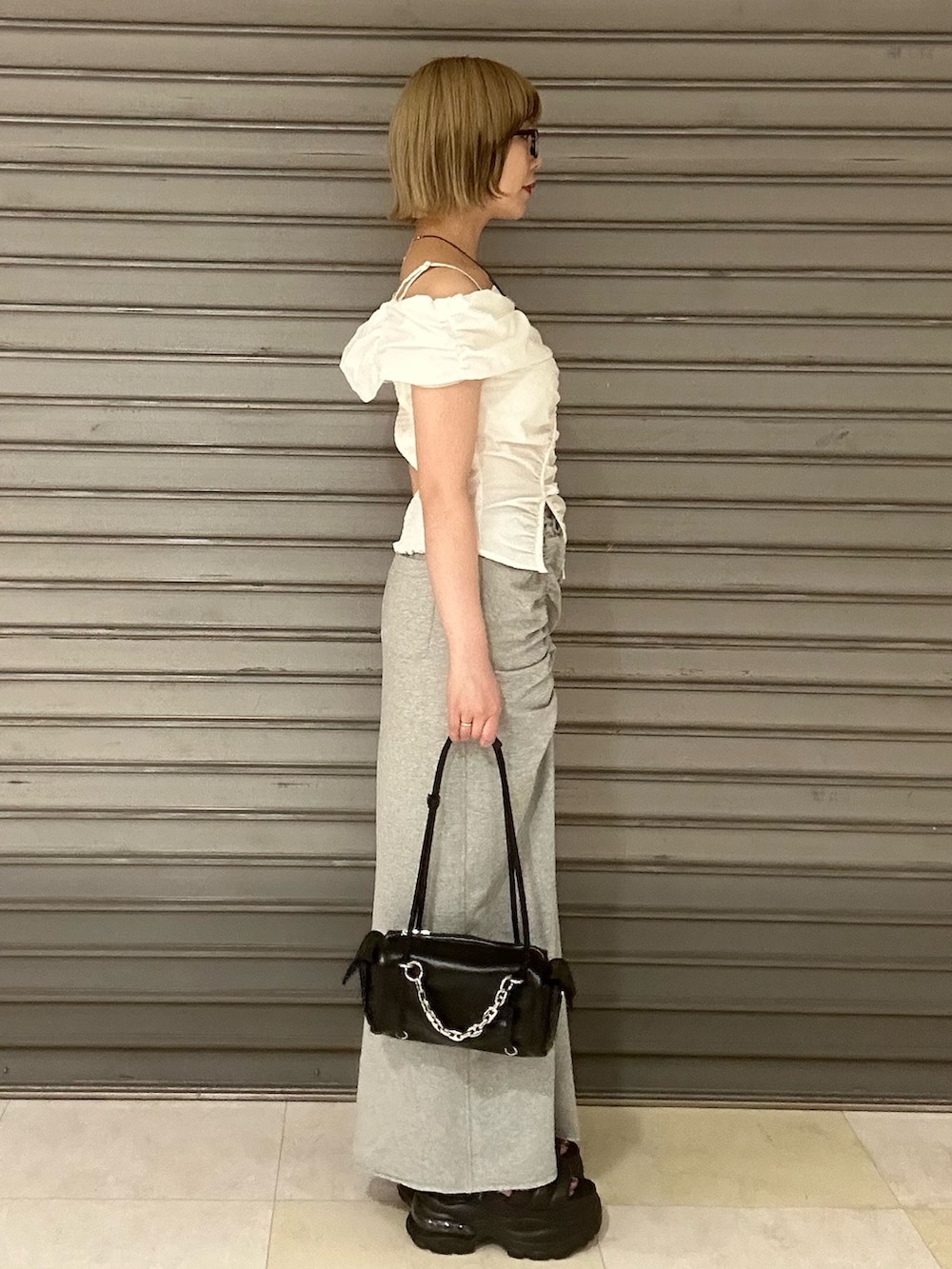 ホワイト系のTシャツ/カットソー、グレー系のスカート、ブラック系のサンダルを着用したレディースの夏コーディネートの2枚目の写真