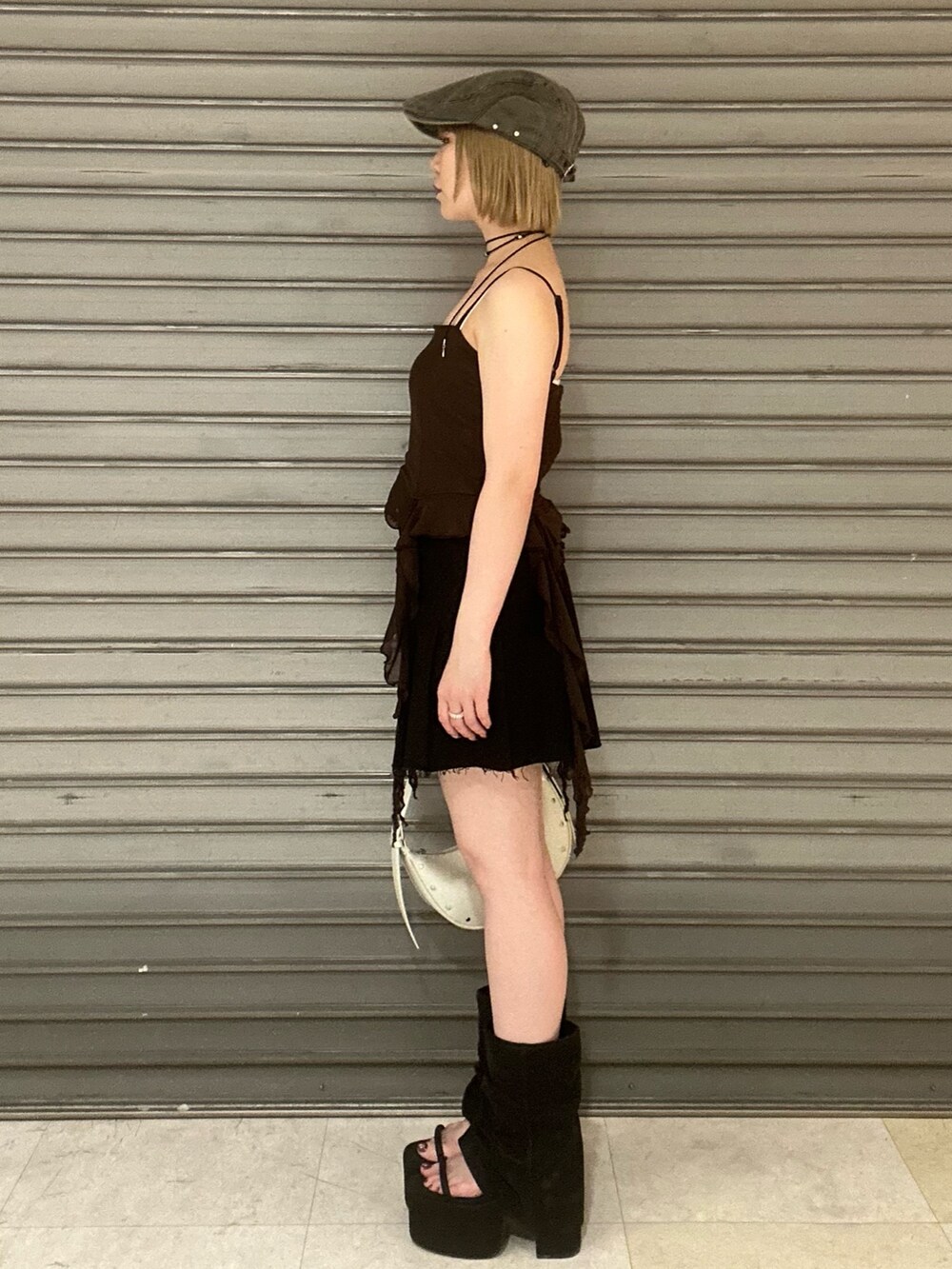 ブラウン系のTシャツ/カットソー、ブラック系のスカート、ブラック系のサンダルを着用したレディースの春コーディネートの2枚目の写真