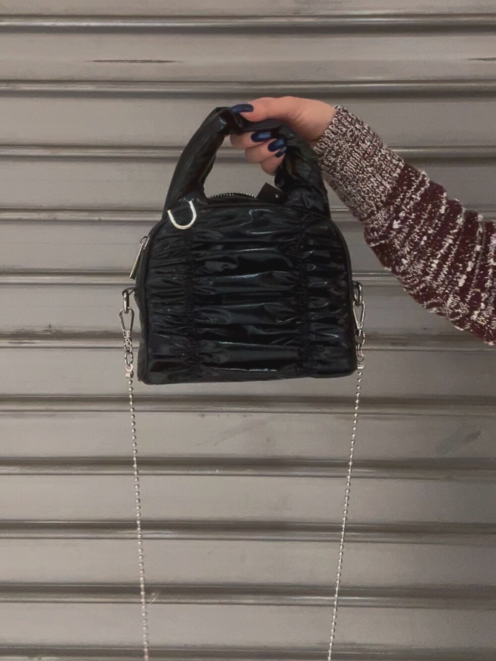 ブラック系のハンドバッグ、レッド系のニット/セーター、ブラック系のデニムパンツを着用したレディースの冬コーディネートの6枚目の写真