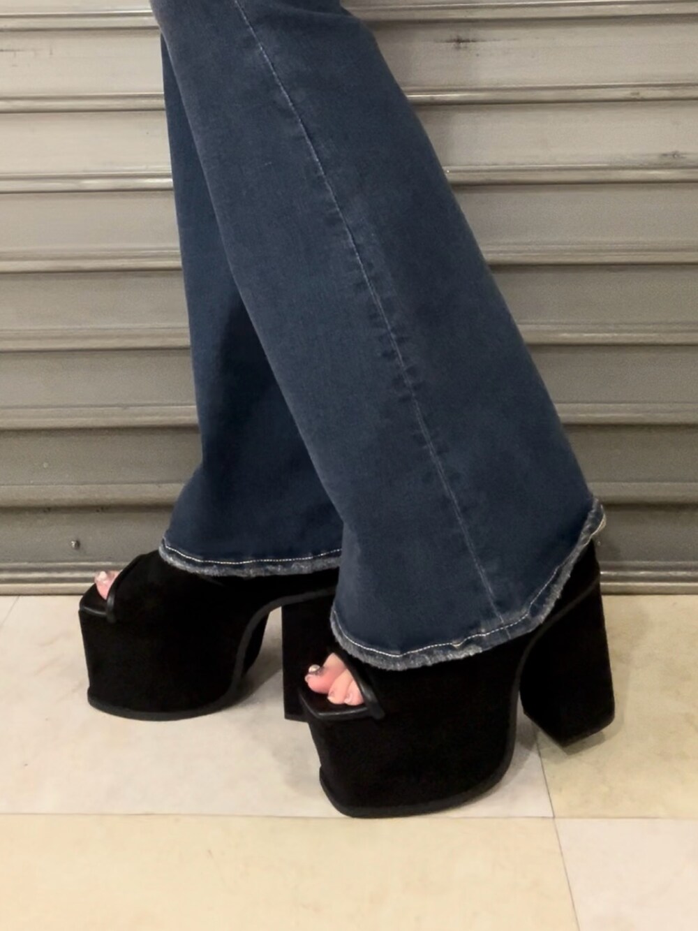 ホワイト系のタンクトップ、ブルー系のデニムパンツ、ブラック系のサンダルを着用したレディースの夏コーディネートの7枚目の写真