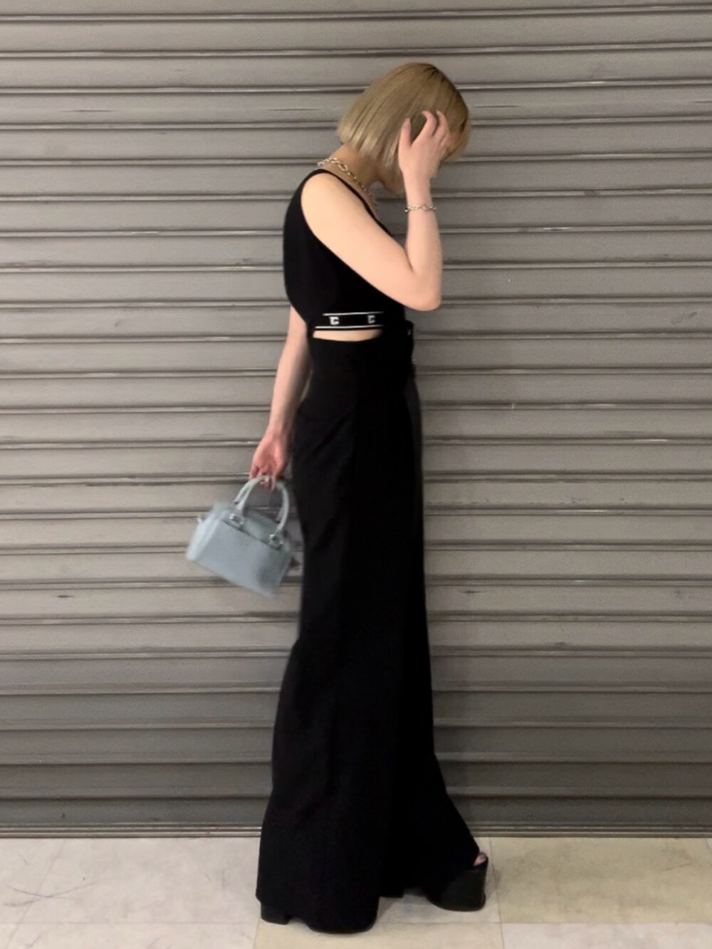 ブラック系のつなぎ/オールインワン、ブラック系のサンダル、ブルー系のハンドバッグを着用したレディースの春コーディネートの2枚目の写真