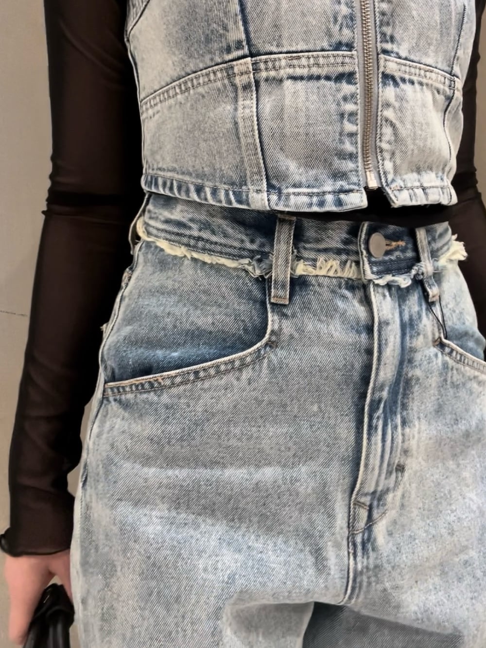 ブルー系のキャミソール、ブラック系のTシャツ/カットソー、ブルー系のデニムパンツを着用したレディースの春コーディネートの5枚目の写真