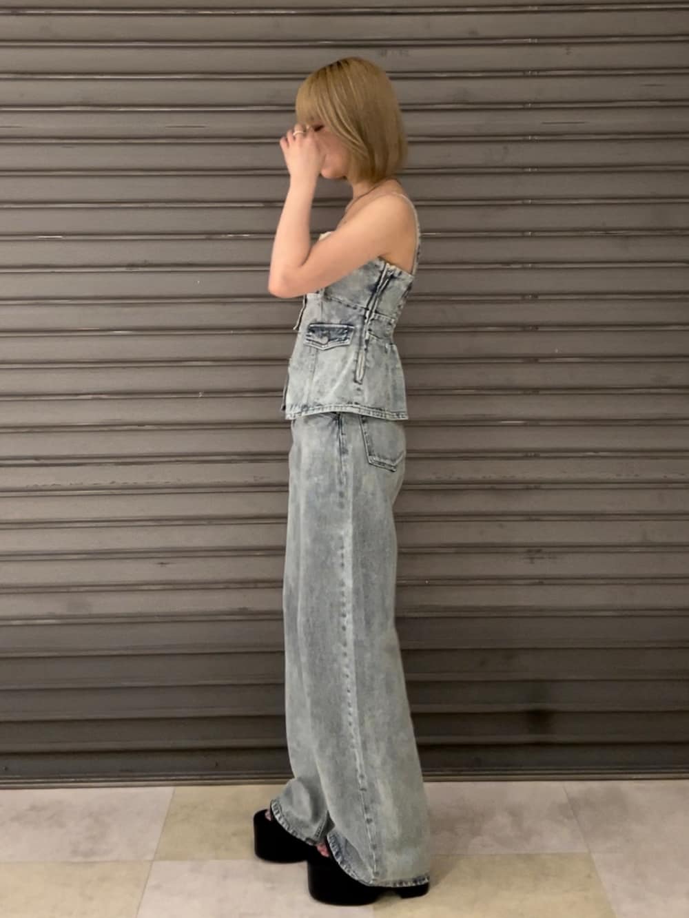 ブルー系のキャミソール、ブルー系のデニムパンツ、ブラック系のサンダルを着用したレディースの夏コーディネートの2枚目の写真