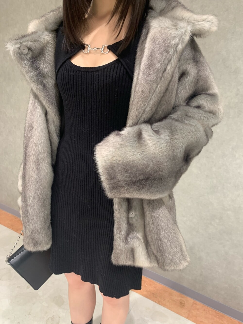 グレー系のその他アウター、ブラック系のブーツ、ブラック系のハンドバッグを着用したレディースの冬コーディネートの2枚目の写真