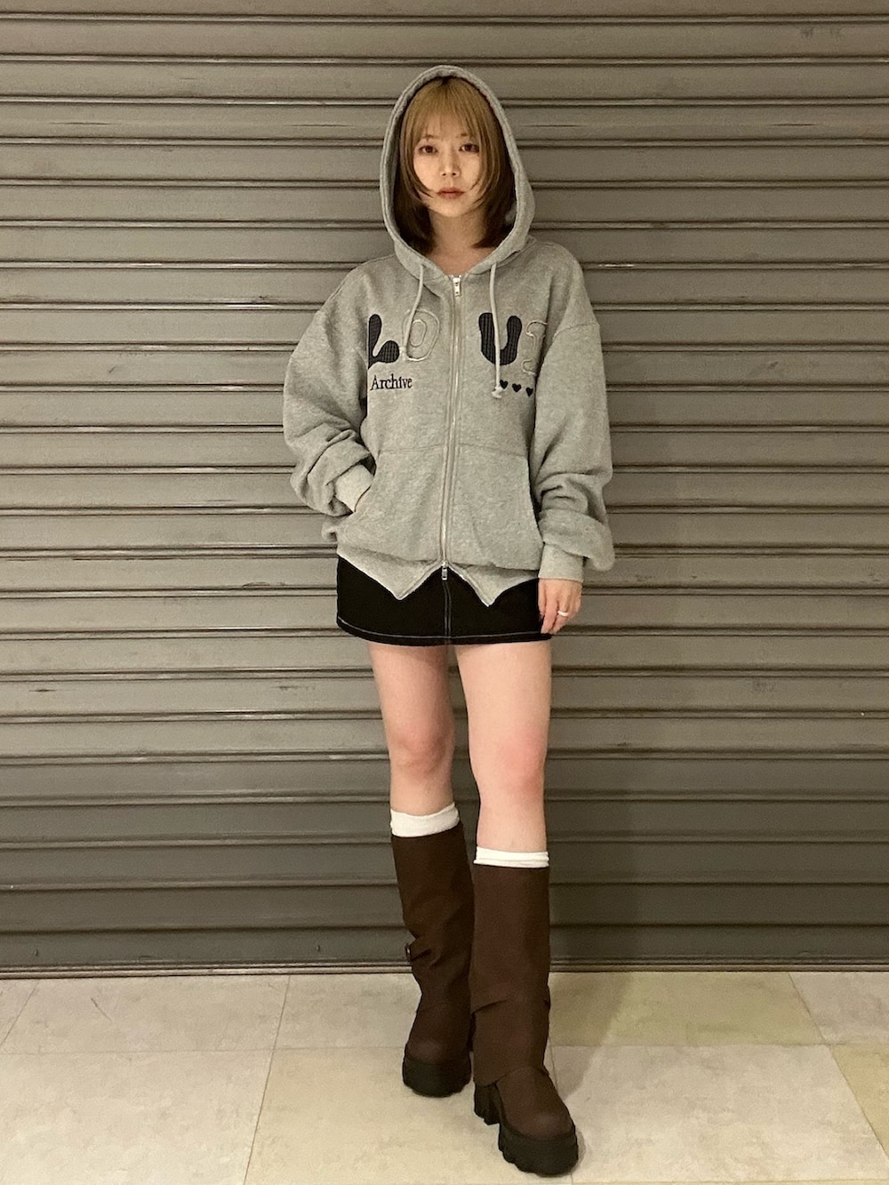 ブルー系のブルゾン、グレー系のパーカー、ブルー系のスカートを着用したレディースの冬コーディネートの2枚目の写真