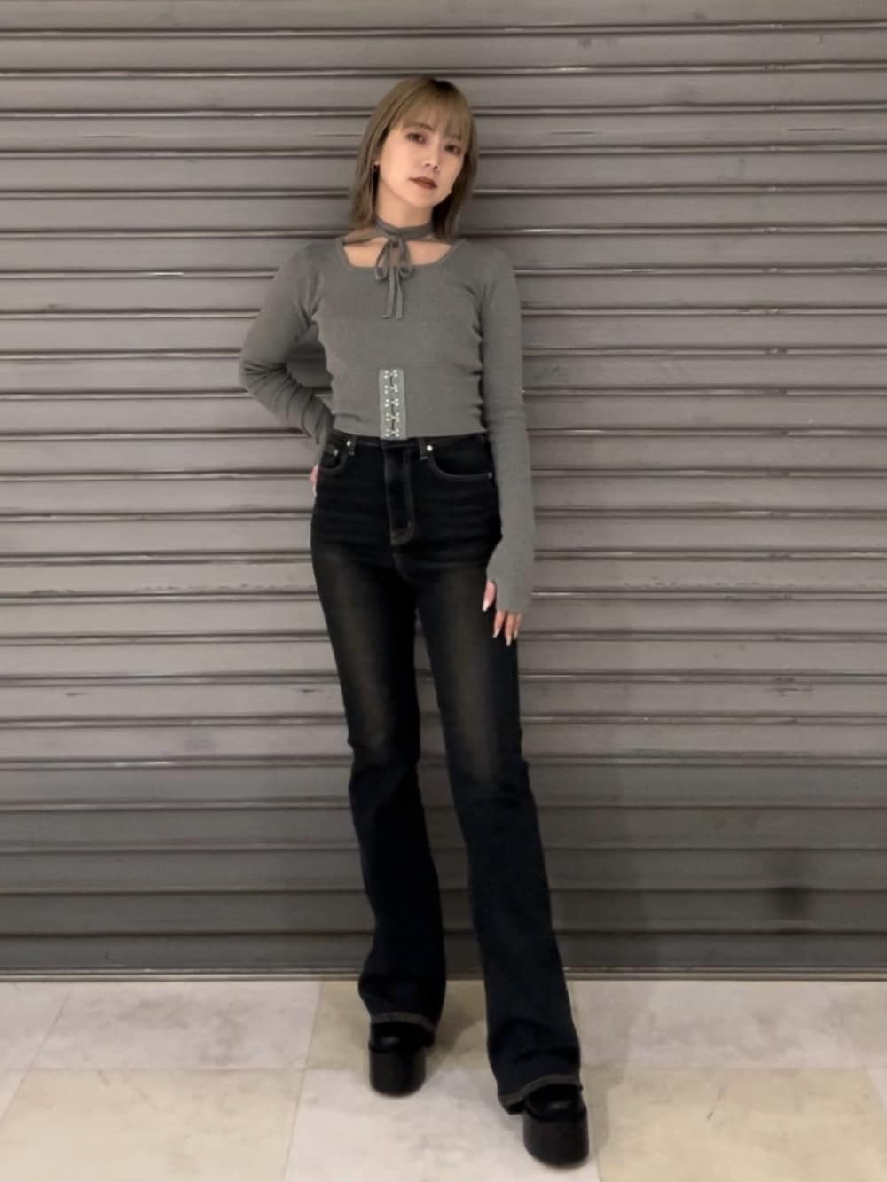 ブルー系のデニムパンツ、グレー系のニット/セーター、ブラック系のブーツを着用したレディースの秋コーディネートの2枚目の写真