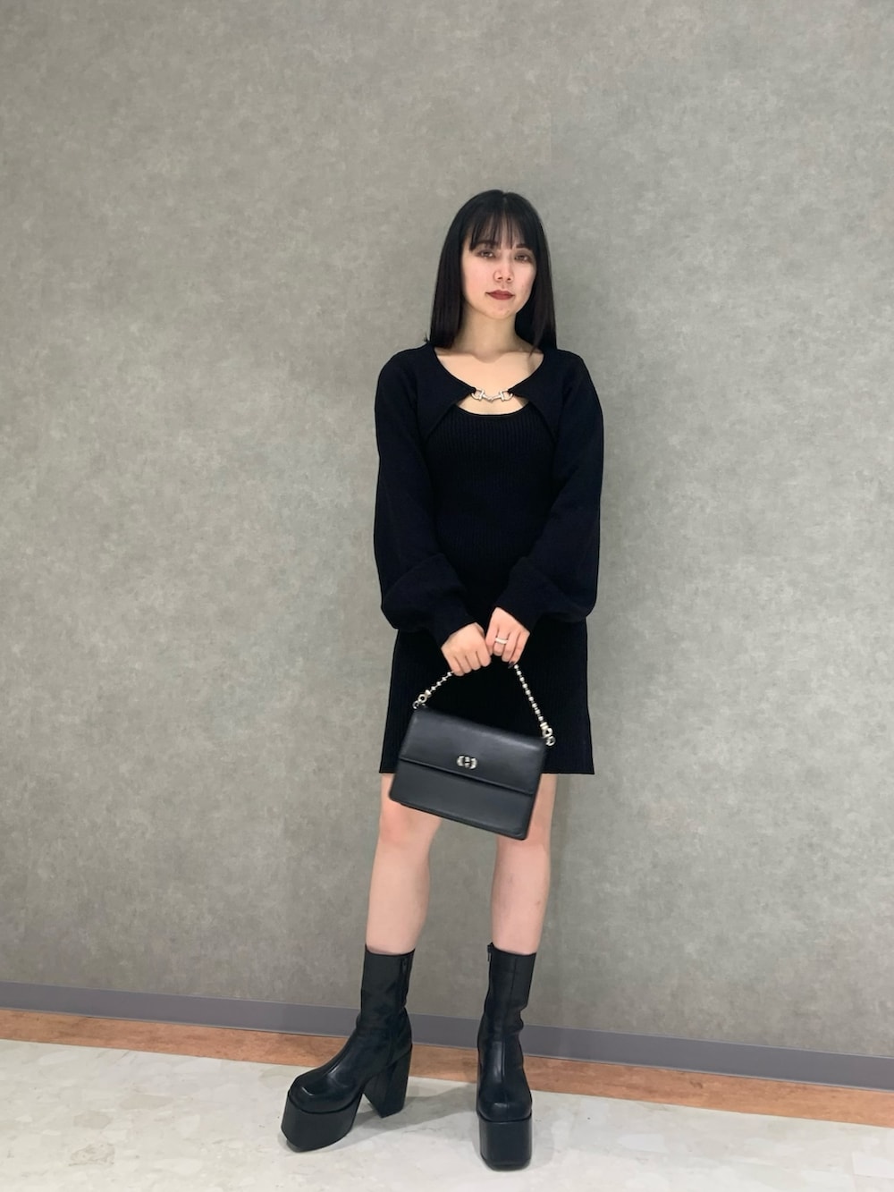 グレー系のその他アウター、ブラック系のブーツ、ブラック系のハンドバッグを着用したレディースの冬コーディネートの3枚目の写真