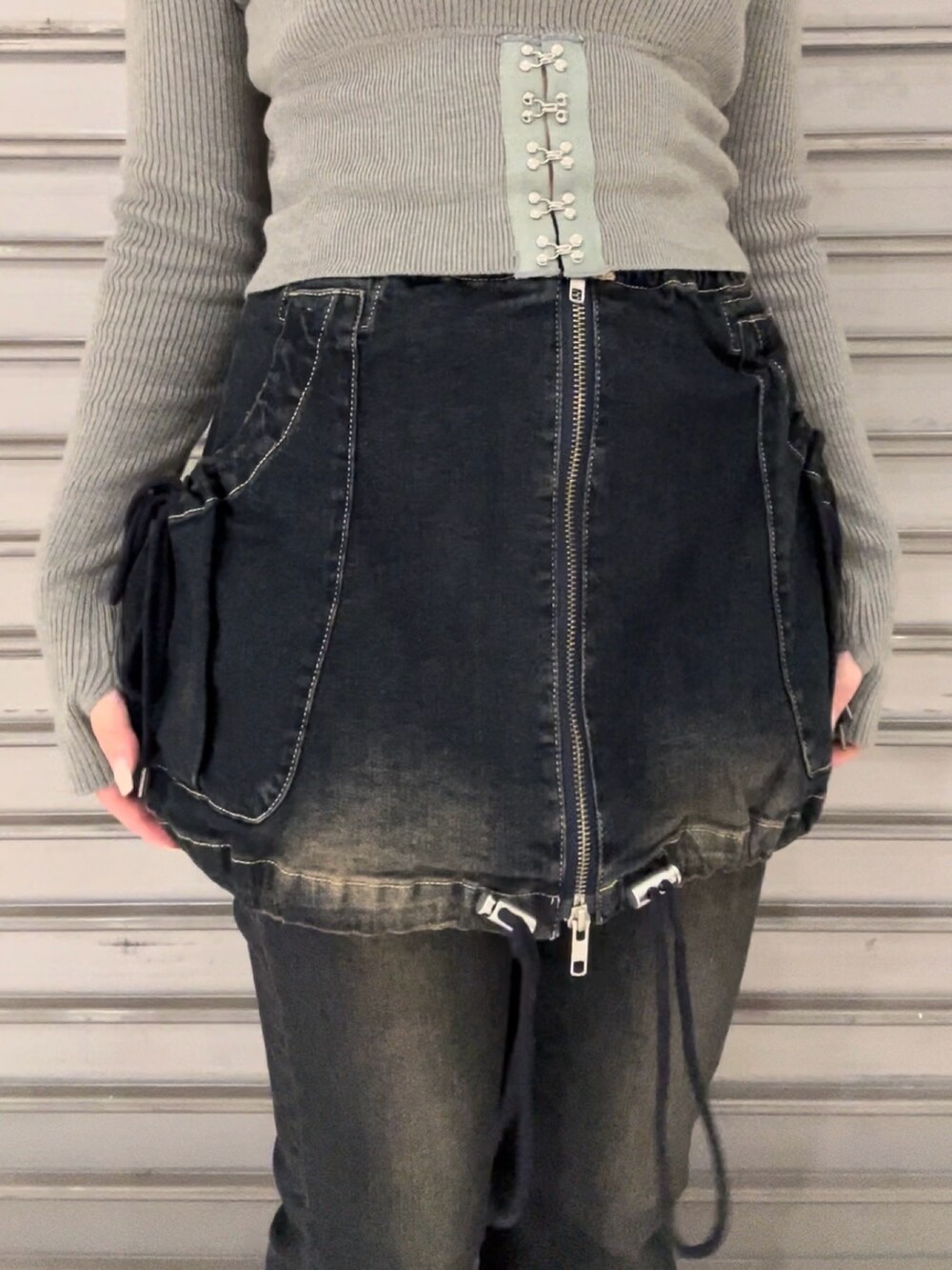 ブルー系のデニムパンツ、グレー系のニット/セーター、ブラック系のブーツを着用したレディースの秋コーディネートの8枚目の写真