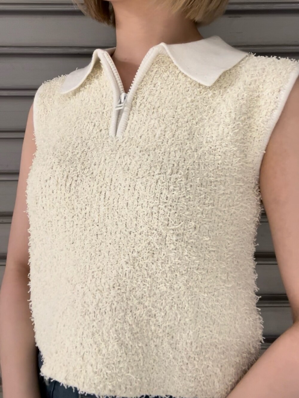 ホワイト系のタンクトップ、ブルー系のデニムパンツ、ブラック系のハンドバッグを着用したレディースの夏コーディネートの4枚目の写真