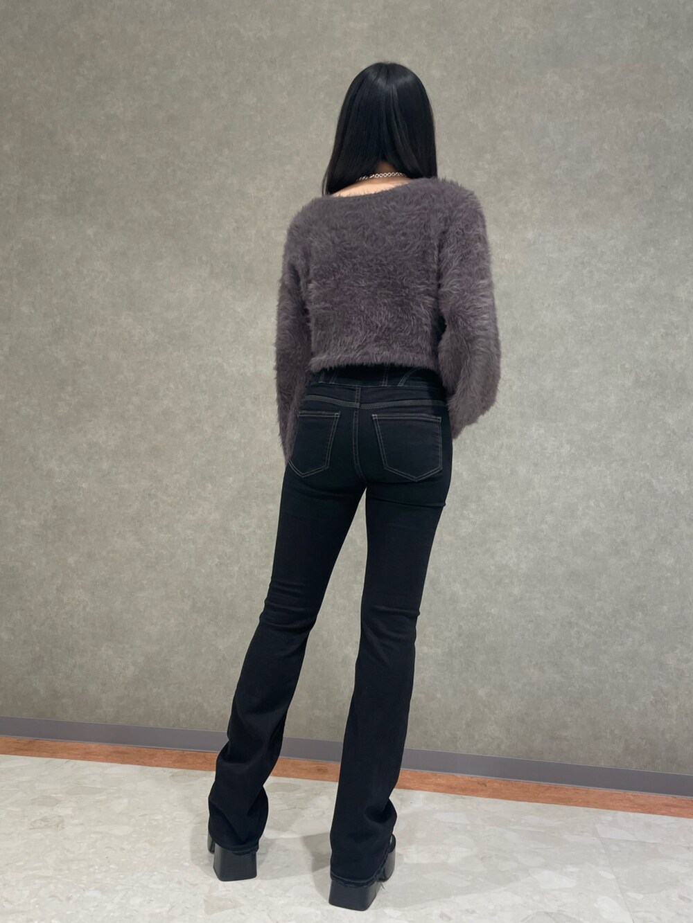 ブラック系のデニムパンツ、グレー系のニット/セーター、ブラック系のローファーを着用したレディースの冬コーディネートの2枚目の写真