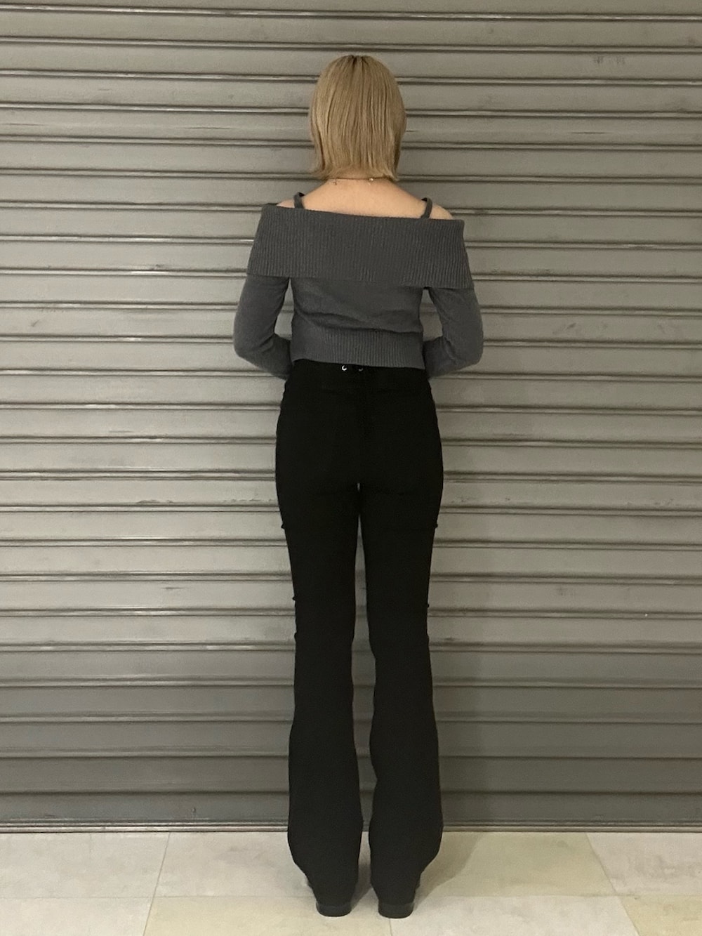 ブラック系のブーツ、グレー系のニット/セーター、ブラック系のデニムパンツを着用したレディースの秋コーディネートの3枚目の写真