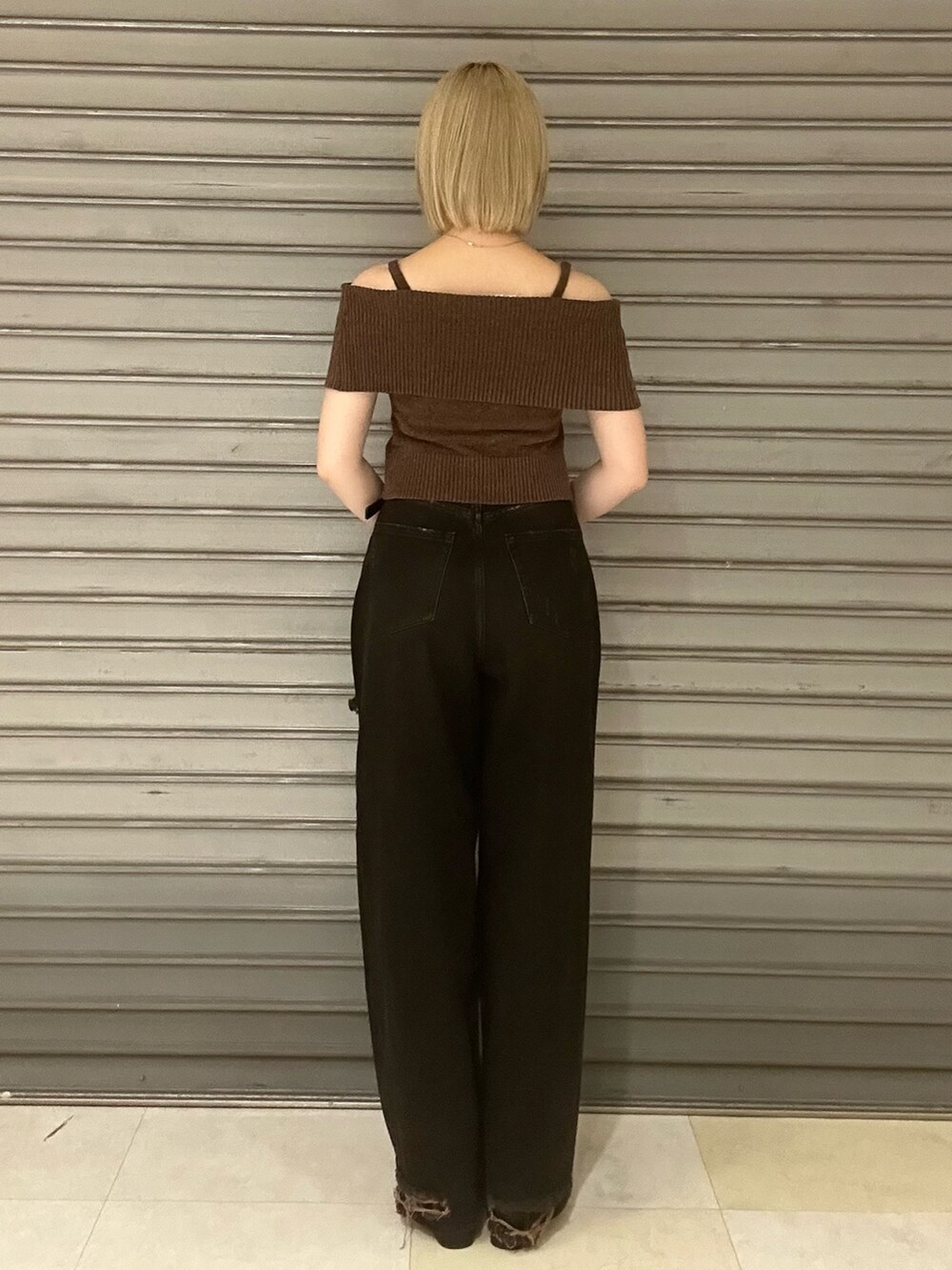 ブラウン系のニット/セーター、ブラック系のデニムパンツ、ブラック系のサンダルを着用したレディースの夏コーディネートの3枚目の写真