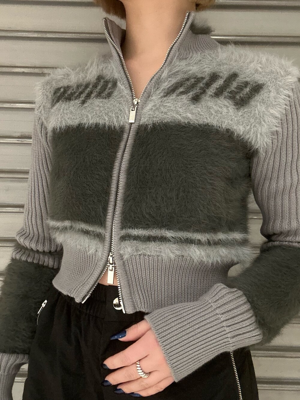 グレー系のニット/セーター、ブラック系のその他パンツ、シルバー系のボストンバッグを着用したレディースの冬コーディネートの4枚目の写真