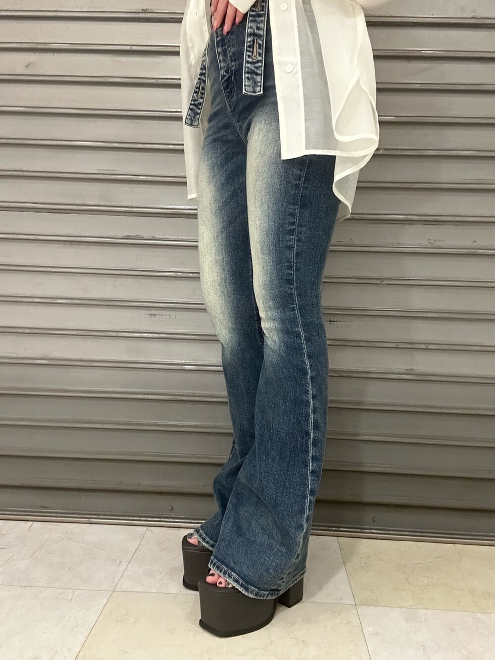 ブルー系のサロペット/オーバーオール、ホワイト系のシャツ/ブラウス、ブラック系のサンダルを着用したレディースの春コーディネートの7枚目の写真