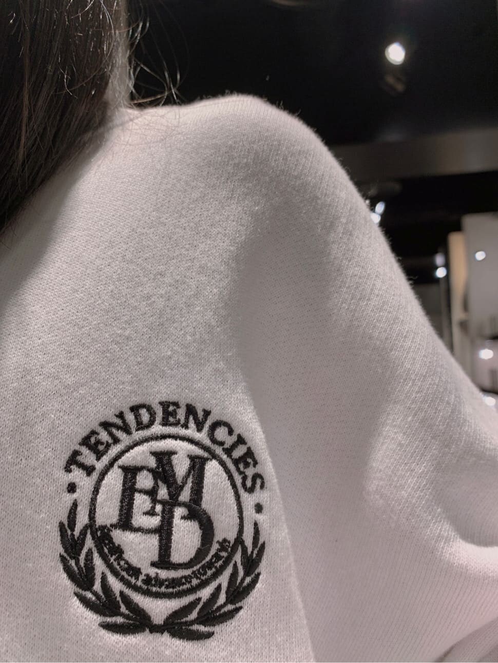 ブラック系のデニムパンツ、ブラック系のブーツ、ホワイト系のスウェットを着用したレディースの秋コーディネートの2枚目の写真