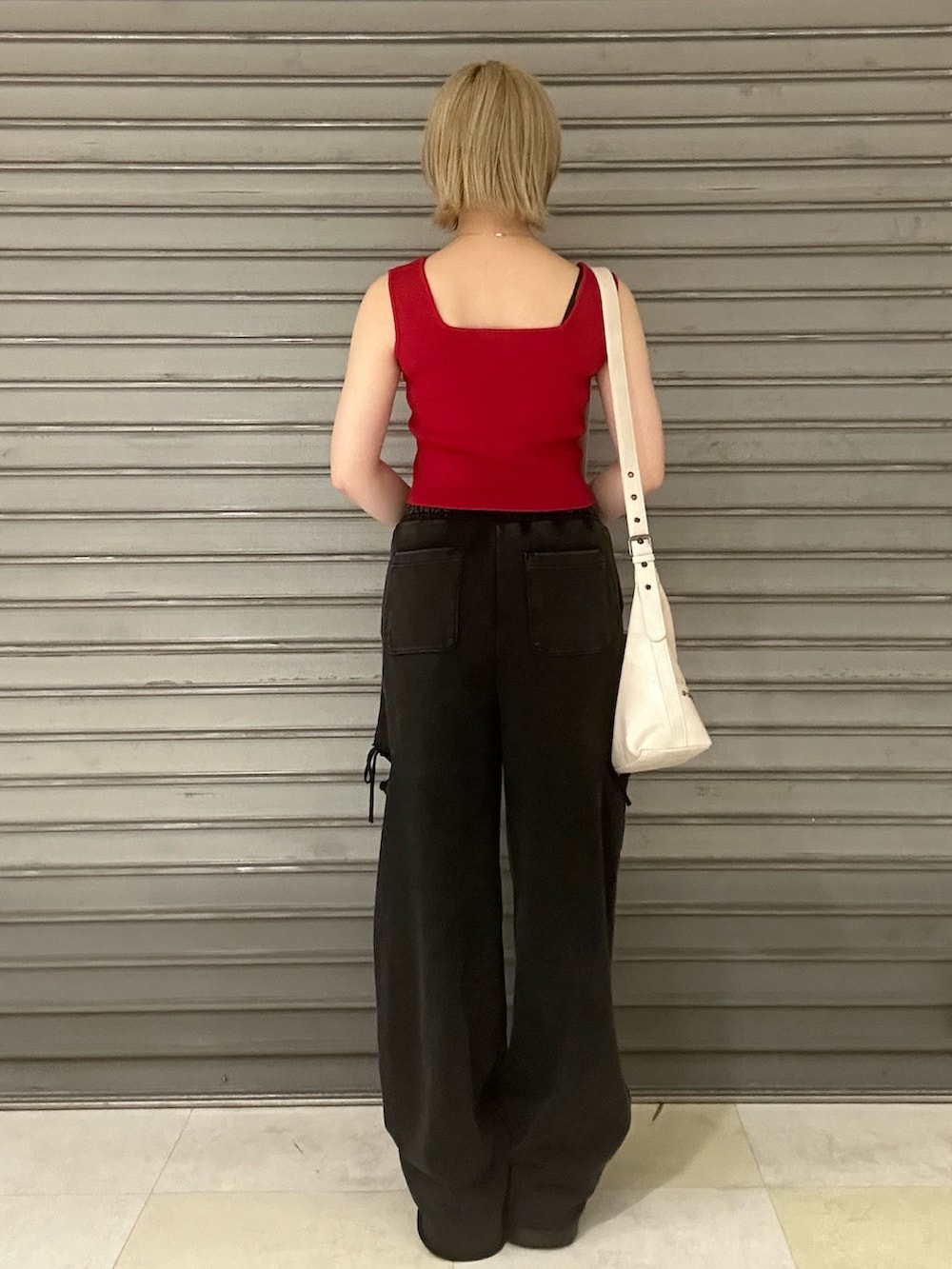 レッド系のTシャツ/カットソー、ブラック系のスウェットパンツ、ブラック系のスニーカーを着用したレディースの夏コーディネートの3枚目の写真