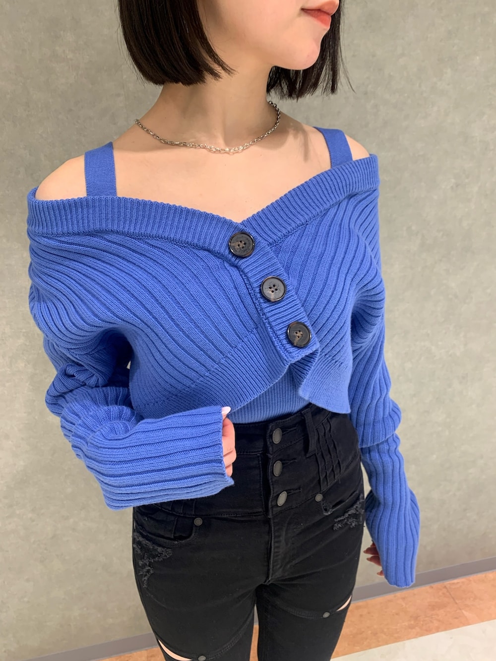 ブラック系のデニムパンツ、ブルー系のカーディガン/ボレロ、ブラック系のブーツを着用したレディースの冬コーディネートの3枚目の写真