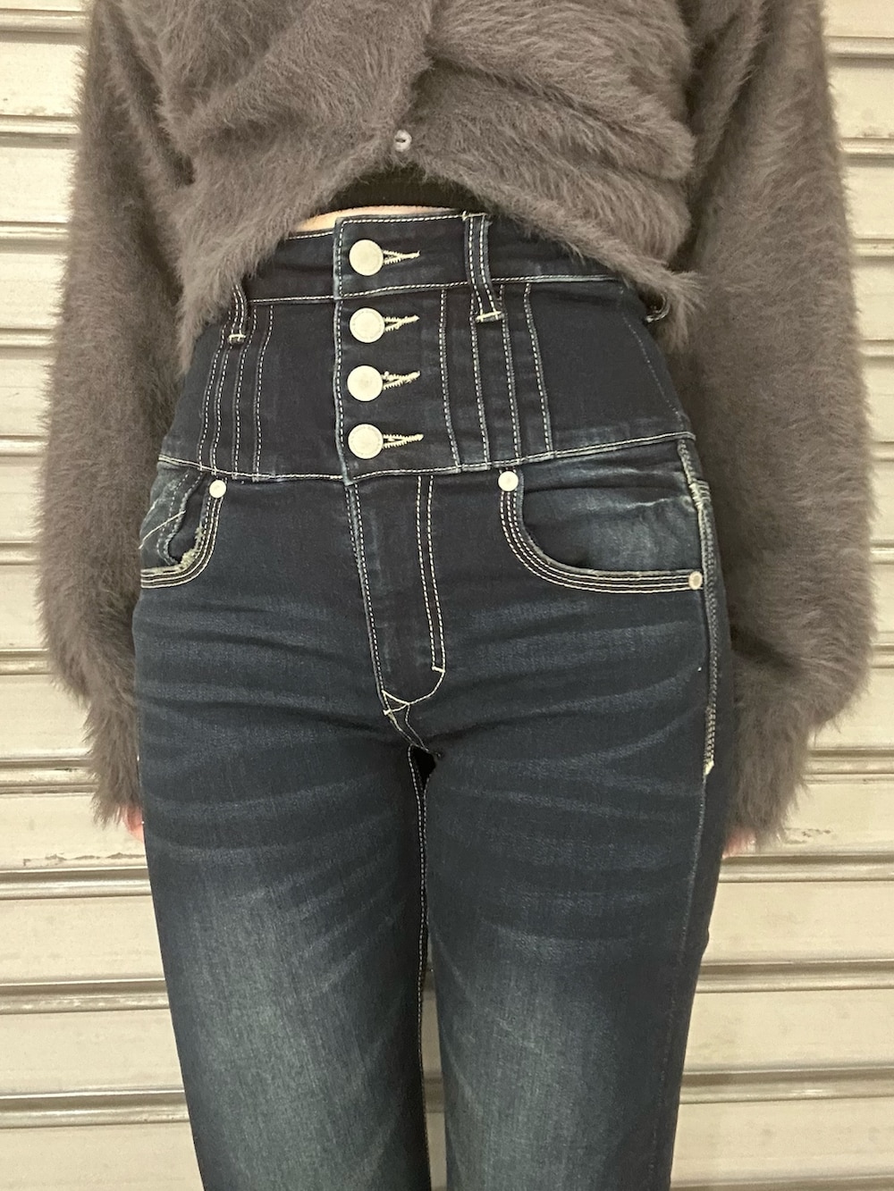 グレー系のニット/セーター、グレー系のTシャツ/カットソー、ブルー系のデニムパンツを着用したレディースの秋コーディネートの5枚目の写真