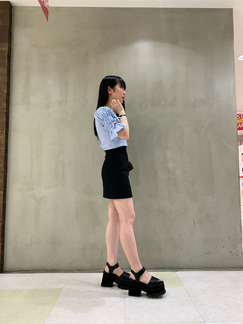 ブラック系のスカート、ブラック系のサンダル、ブルー系のシャツ/ブラウスを着用したレディースの夏コーディネートの2枚目の写真