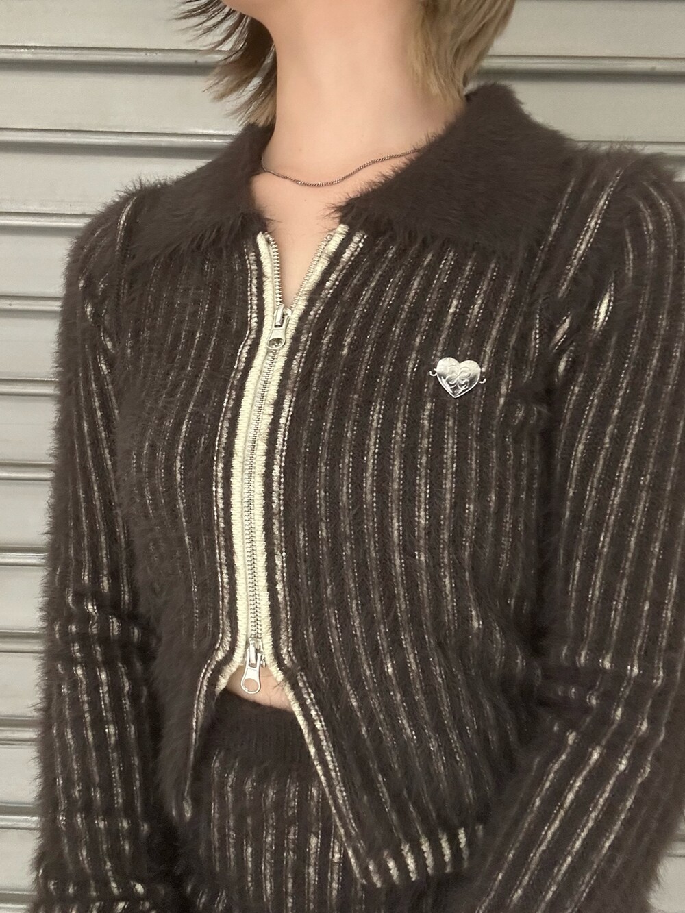 ブラウン系のニット/セーター、ブラウン系のスカート、ブラック系のブーツを着用したレディースの秋コーディネートの4枚目の写真