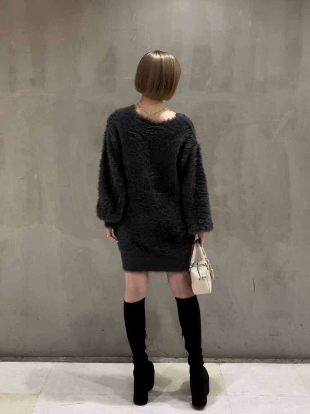 その他のブーツ、ホワイト系のダウンジャケット/コート、グレー系のワンピースを着用したレディースの冬コーディネートの3枚目の写真