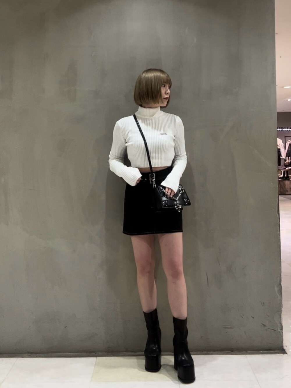 ホワイト系のニット/セーター、ブラウン系のブルゾン、ブラック系のスカートを着用したレディースの冬コーディネートの2枚目の写真