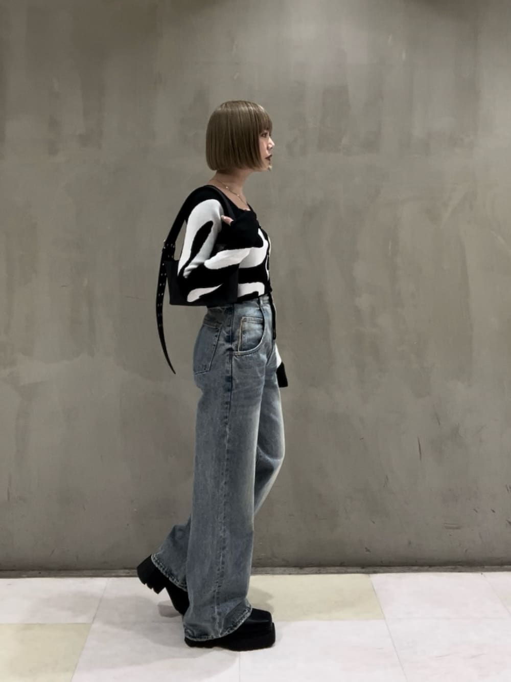 その他のニット/セーター、ホワイト系のキャミソール、ブラック系のショルダーバッグを着用したレディースの冬コーディネートの2枚目の写真